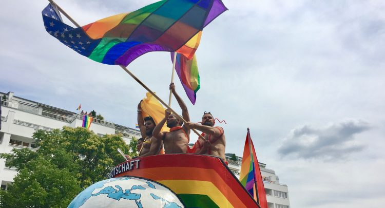 Drei Männer oben ohne auf dem CSD Truck 2016 die die Regenbogenfahne schwenken